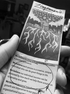 Black and white photo of a hand holding the Zingerman's Statement of Beliefs