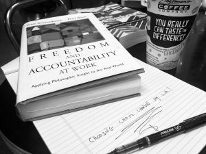 black and white photo of book on a notepad and a coffee cup