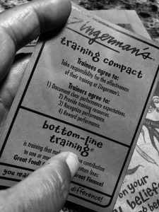 black and white photo of hand holding the Zingerman's Training Compact